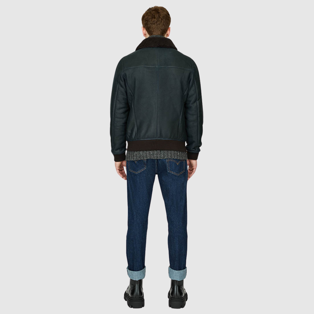 The Perez Navy Brown Shearling Bomber combines classic bomber styling with the luxury of supple nappa leather and a plush curly wool collar. Designed for a true-to-size fit, it features ribbed cuffs and a ribbed waistband for a secure, comfortable silhouette. Functional details such as zip side pockets and an interior zip pocket ensure everyday practicality, while the standard front zip closure keeps the design streamlined. Perez delivers timeless bomber attitude with a modern shearling upgrade.