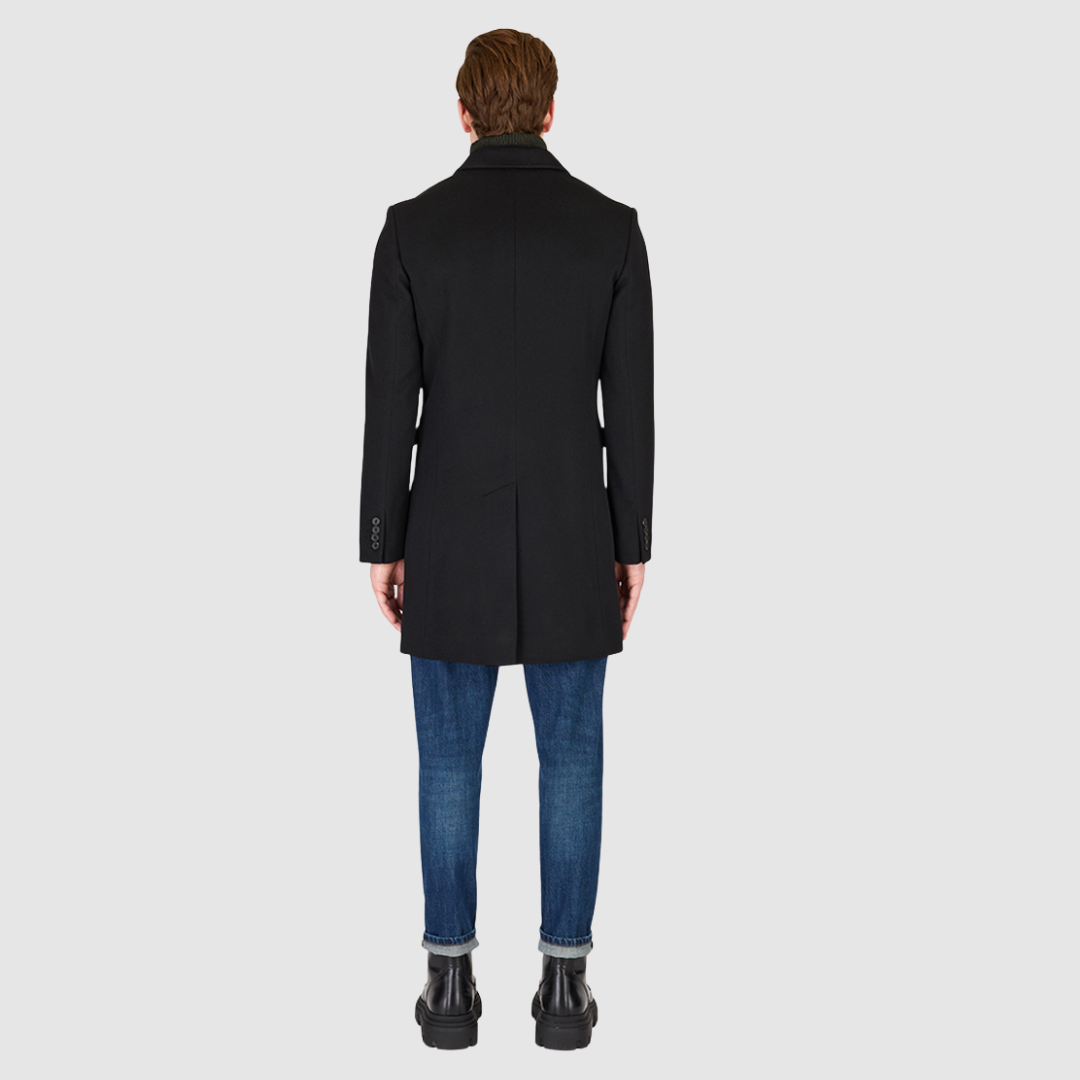 The Dylan Black Loro Piana Wool Coat captures refined sophistication through meticulous tailoring and Italian craftsmanship. Made from Loro Piana superfine wool, this single-breasted coat offers a slim fit through the arms and body, creating a sharp, modern silhouette ideal for both professional and evening wear. The notch collar, button-detailed cuffs, and flap side pockets add subtle sophistication, while the back vent ensures ease of movement and comfort. A single welt chest pocket completes this timeles