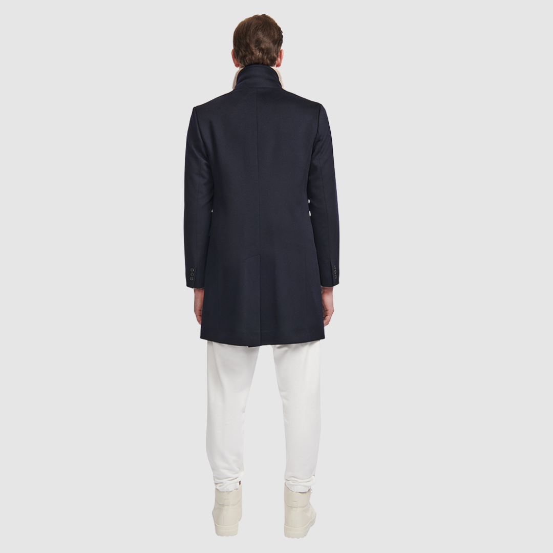The Dylan Loro Piana Wool Coat captures refined sophistication through meticulous tailoring and Italian craftsmanship. Made from Loro Piana superfine wool, this single-breasted coat offers a slim fit through the arms and body, creating a sharp, modern silhouette ideal for both professional and evening wear. The notch collar, button-detailed cuffs, and flap side pockets add subtle sophistication, while the back vent ensures ease of movement and comfort. A single welt chest pocket completes this timeless look
