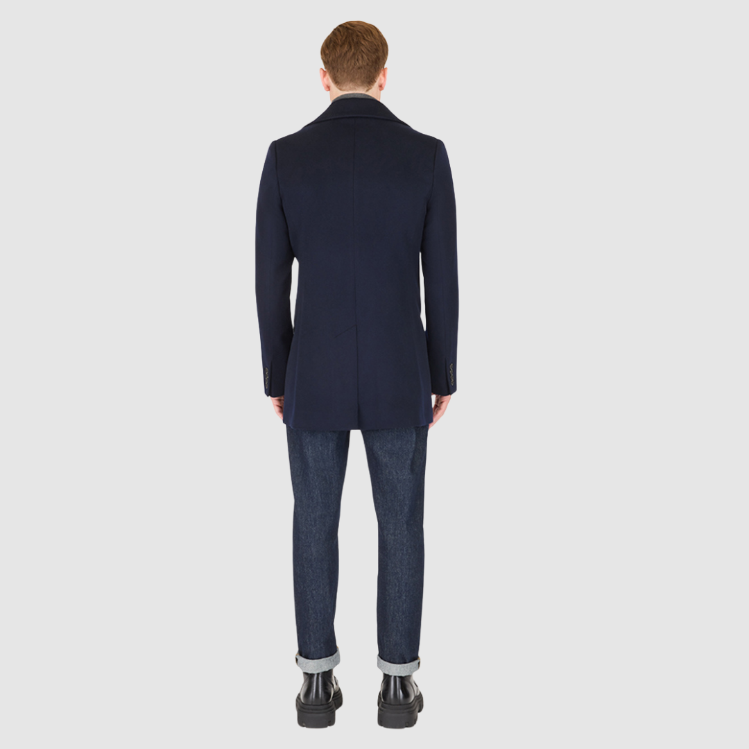 The David Navy Loro Piana Wool Jacket embodies timeless sophistication and precision tailoring. Crafted from Loro Piana superfine wool, this double-breasted jacket offers a refined structure and a luxurious hand-feel that elevates any modern wardrobe. Designed with a regular shoulder and a fitted silhouette through the arms and body, it delivers a sharp, polished profile. The peak lapel collar, back vent, and single welt pockets underscore its heritage-inspired craftsmanship, merging Italian elegance with c