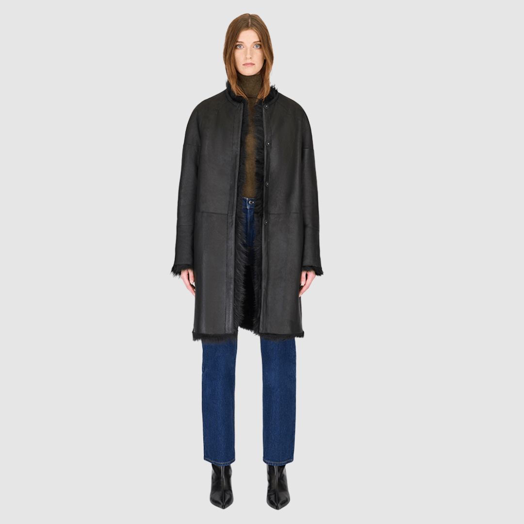 The ALLORA Jacket is a luxury reversible shearling teddy crafted in Jet Toscana for a rich and modern finish. Designed as a collarless regular fit silhouette, it effortlessly flips from plush wool-out shearling to a sleek nappa skin-out jacket, offering two looks in one. With its generous fit through the shoulders, arms, and torso, ALLORA balances comfort and style. Functional slash side pockets on both sides and a front snap closure complete this elevated women’s reversible shearling jacket.cket.