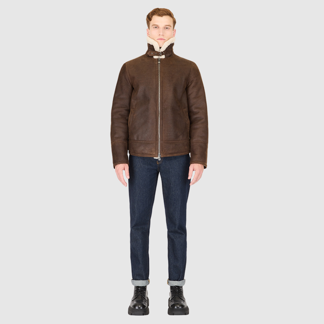 The Kane Arabica Shearling Moto combines heritage craftsmanship with modern moto design. Crafted from supple nappa leather with a plush curly wool collar, it fits comfortably through the shoulders and chest for ease of movement. Featuring a notch collar with buckle detailing, interior patch pockets, and exterior single welt side pockets, it balances functional utility with polished style. A front zip closure completes the sleek, timeless silhouette.