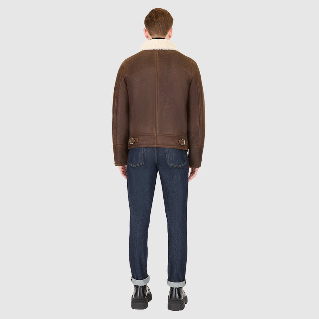 The Kane Arabica Shearling Moto combines heritage craftsmanship with modern moto design. Crafted from supple nappa leather with a plush curly wool collar, it fits comfortably through the shoulders and chest for ease of movement. Featuring a notch collar with buckle detailing, interior patch pockets, and exterior single welt side pockets, it balances functional utility with polished style. A front zip closure completes the sleek, timeless silhouette.