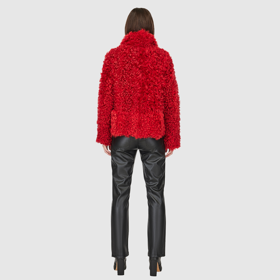 This cropped teddy jacket features a reversible design, with wool-out on one side and nappa-out on the other. The relaxed shoulder, spread collar, and slash side pockets provide comfort and functionality, while the front zip closure adds a practical touch.