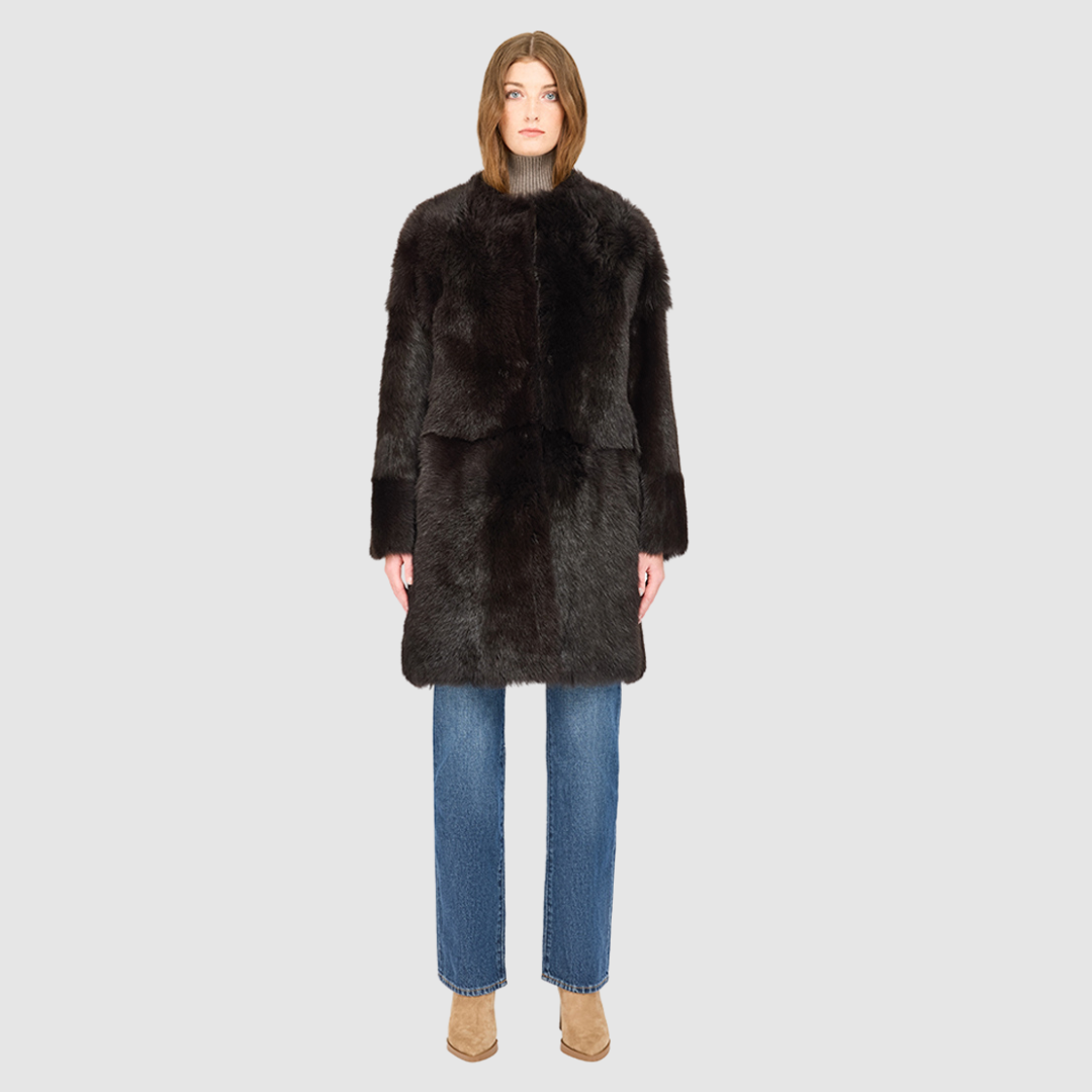 The ALLORA Jacket is a luxury reversible shearling teddy crafted in chocolate silky Toscana for a rich and modern finish. Designed as a collarless oversized silhouette, it effortlessly flips from plush wool-out shearling to a sleek nappa skin-out jacket, offering two looks in one. With its generous fit through the shoulders, arms, and torso, ALLORA balances comfort and style. Functional slash side pockets on both sides and a front snap closure complete this elevated women’s reversible shearling jacket.