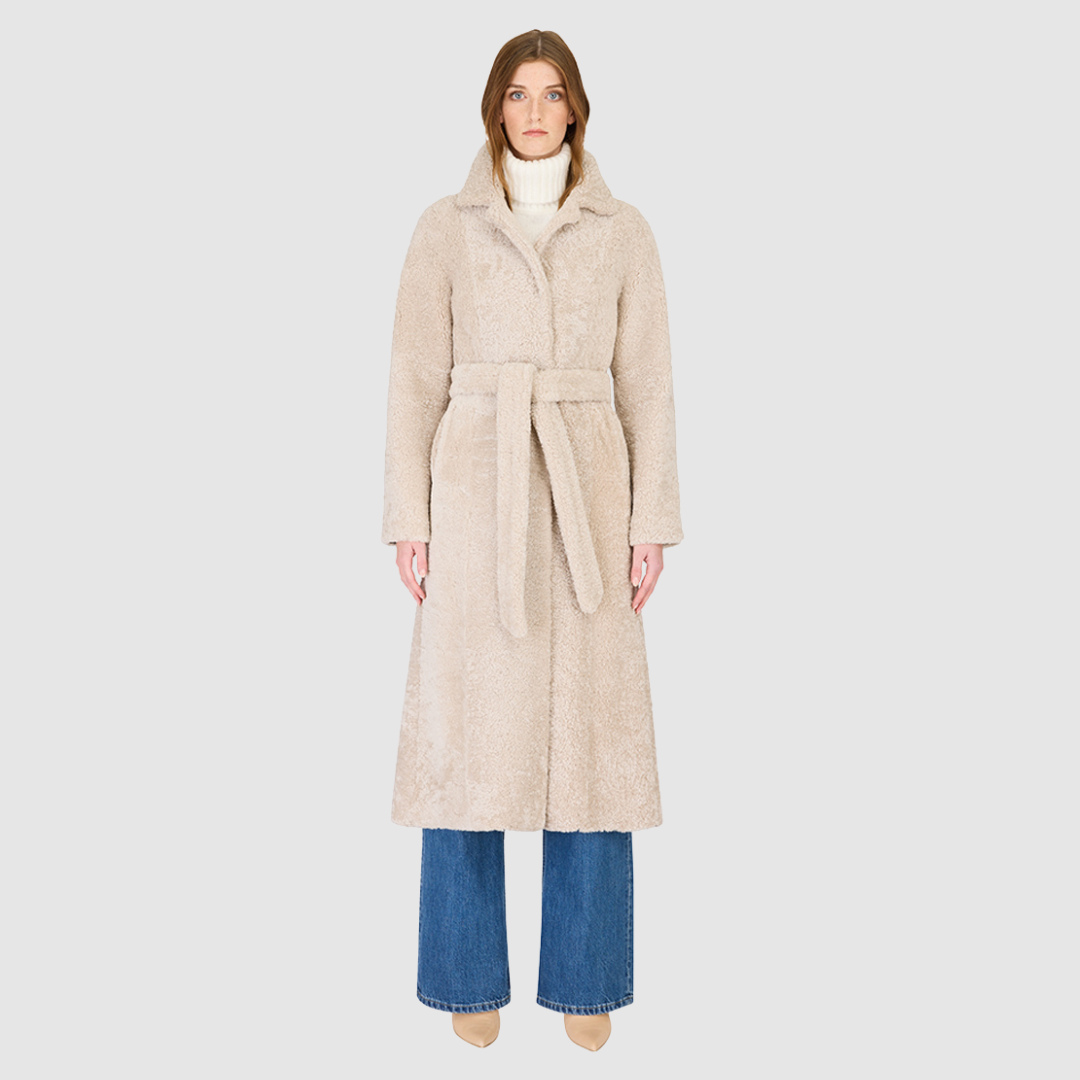The EMBER Coat is a heritage-inspired wool-out curly mouton wrap crafted in rich black for timeless sophistication. Designed with a regular shoulder and fitted torso, it offers a flattering silhouette while maintaining comfort and warmth. A small curly wool notch collar, slash side pockets, and a front snap with tie belt closure combine function with elevated style. Fully lined for luxury, EMBER is perfect for après-ski evenings or refined everyday winter wear.