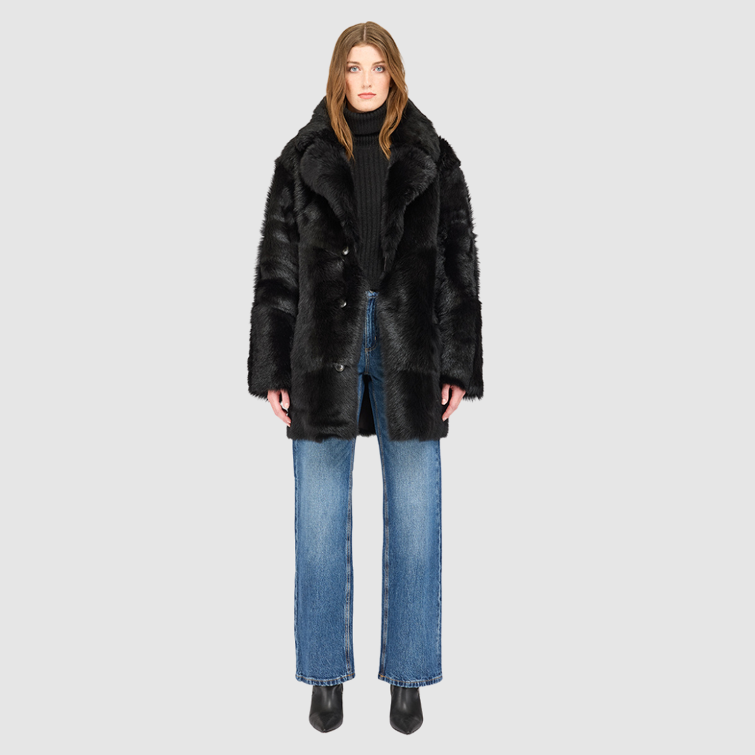 The LUREEN Coat is a luxury reversible semi-suede outerwear piece crafted in Java Toscana. Designed to flip seamlessly from smooth semi-suede to plush Toscana wool teddy, it offers versatile styling for cold-weather layering. The wool-out Toscana seam detailing on the semi-suede side, combined with a drop shoulder and relaxed fit through shoulders, arms, and torso, creates effortless volume and structure. An oversized Toscana notch collar, patch pockets on both sides, and a front button closure.