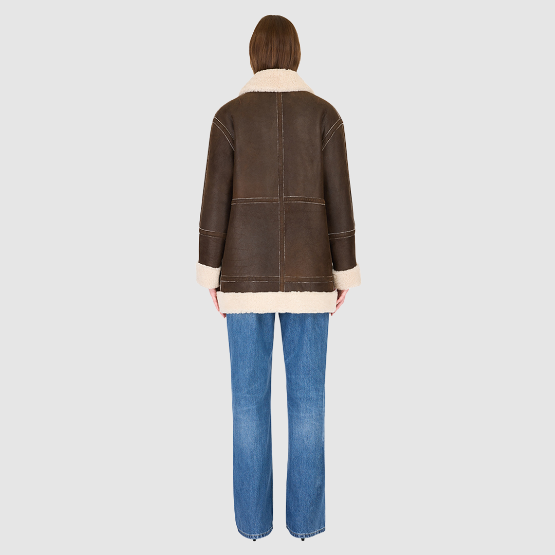 The DEZ Jacket is a heritage-inspired reversible medium-length shearling moto crafted in arabica suede leather with plush curly wool teddy on the reverse. Designed for a relaxed silhouette with drop shoulders, curly wool collar and trims, and a straight fit, DEZ combines modern edge with timeless texture. Functional patch pockets on both suede and wool sides and a front zip closure make this jacket as practical as it is versatile, perfect for après-ski layering or elevated city styling.