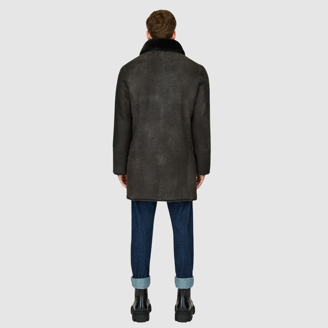 The Edson Black Vintage Reversible Shearling Jacket is a mid-length men’s coat engineered for winter warmth and versatile styling. Crafted from luxe suede with a plush ironed wool teddy reverse, it delivers two distinct silhouettes: structured and tailored when suede-out, or relaxed and oversized when wool-out. Designed with a spread collar, raw edge detailing, and functional dual pockets, this jacket provides effortless layering and superior cold-weather protection. Edson balances timeless shearling crafts