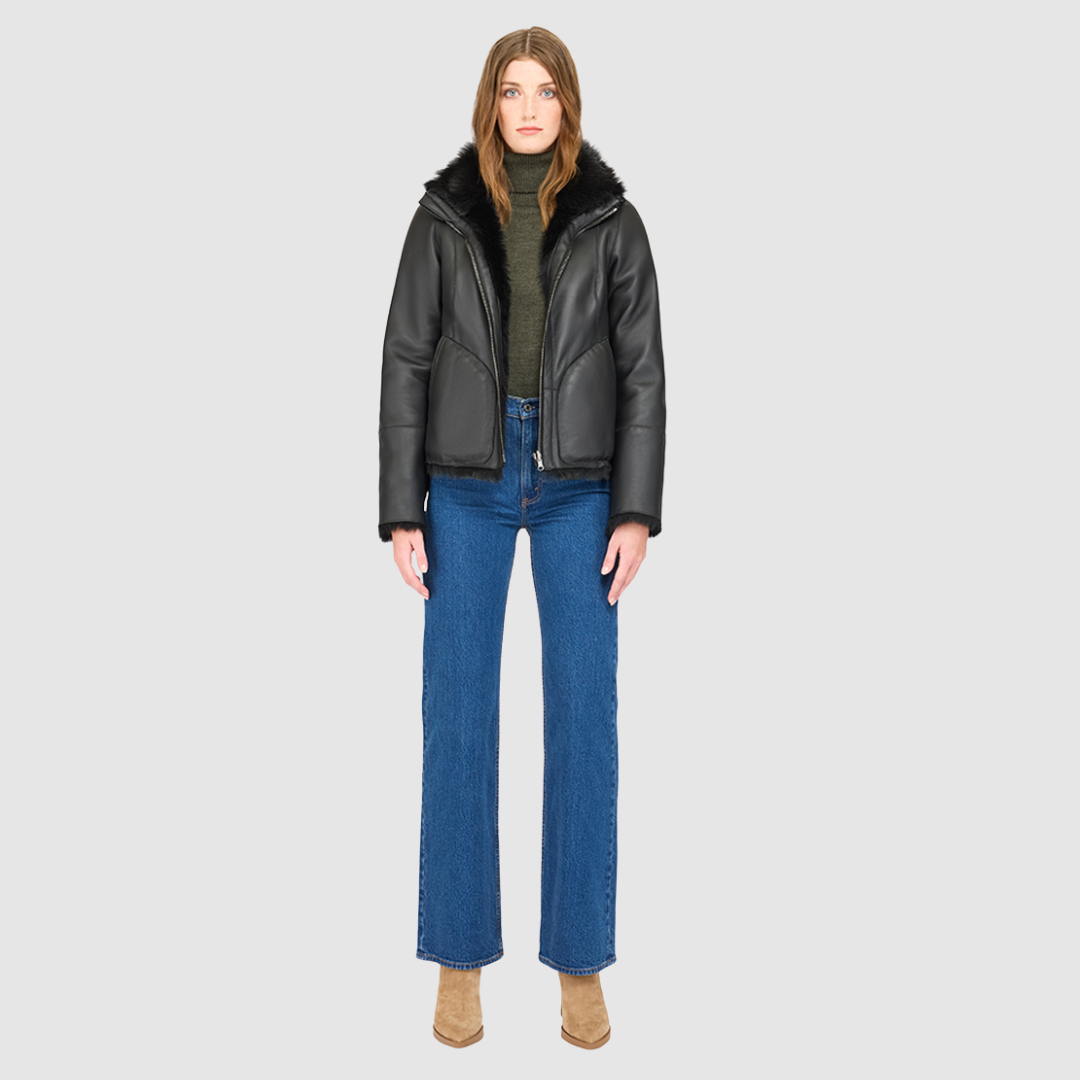 This cropped teddy jacket features a reversible design, with wool-out on one side and nappa-out on the other. The relaxed shoulder, spread collar, and slash side pockets provide comfort and functionality, while the front zip closure adds a practical touch.