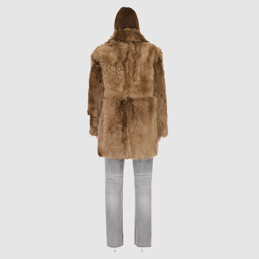 The SEER Jacket is a luxurious oversized outerwear piece crafted in Latte Toscana wool-out teddy. Designed with a structured shoulder and oversized Toscana notch collar, it delivers a bold, elevated silhouette. Fully lined for comfort, the jacket features slash side pockets for functionality and a single-breasted button closure for a polished finish. SEER combines plush texture with timeless tailoring for a standout cold-weather essential.