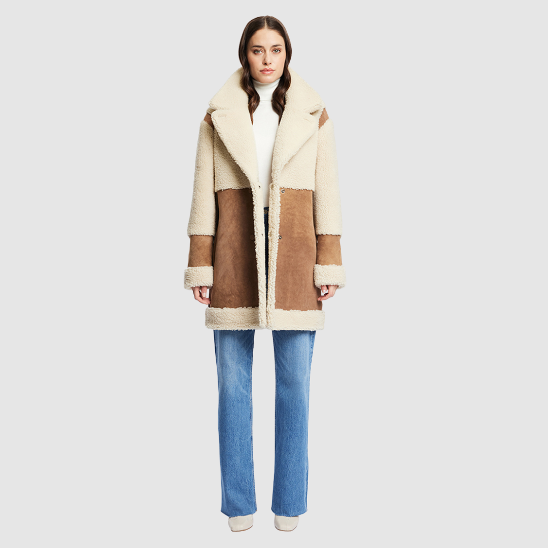 The URBAN Reversible Shearling Jacket fuses contemporary design with timeless shearling craftsmanship. Cut in an oversized silhouette with relaxed shoulders, deep armholes, and wide sleeves, it offers effortless comfort with a modern edge. Crafted from sleek cashew suede and plush beige curly wool, its fully reversible construction allows for versatile styling. With its straight fit and clean snap closure, URBAN is a bold statement piece ideal for both heritage looks and après-ski layering.