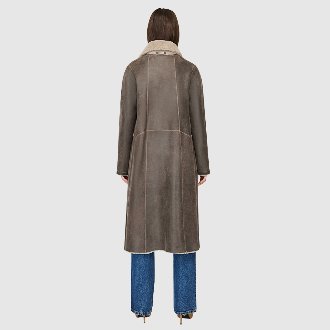 Introducing Zira, our vintage-inspired reversible nappa curly wool shearling coat. This elegant piece features a classic notch collar and effortlessly reverses to a cozy curly wool teddy. Designed with a relaxed dropped shoulder, 3-button closure, and a tie belt at the waist for a flattering fit, it offers both style and comfort. Practical zip pockets on the nappa side reverse to patch pockets on the teddy side, making Zira a versatile must-have for winter fashion.