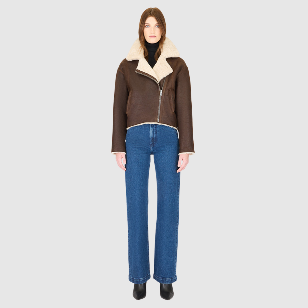 Introducing our women's reversible nappa cropped moto**, perfect for winter. This relaxed-fit coat reverses to a cozy curly wool teddy and features a drop shoulder and relaxed batwing sleeves for a chic look. The oversized notch collar adds bold style, while single welt side pockets on the nappa side and slash pockets on the curly wool side offer practicality. Finished with an asymmetrical front zip and single button closure, it's a versatile wardrobe essential.