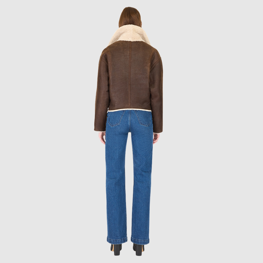 Introducing our women's reversible nappa cropped moto**, perfect for winter. This relaxed-fit coat reverses to a cozy curly wool teddy and features a drop shoulder and relaxed batwing sleeves for a chic look. The oversized notch collar adds bold style, while single welt side pockets on the nappa side and slash pockets on the curly wool side offer practicality. Finished with an asymmetrical front zip and single button closure, it's a versatile wardrobe essential.