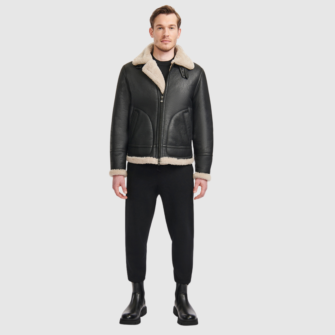 The Ariel Black Beige Shearling Aviator Jacket channels classic aviator style with a modern update, crafted from supple nappa leather and lined with curly wool shearling. Featuring a curly wool collar and trims, oversized welt pockets with stitch detailing, and adjustable buckle details at the collar and waistband, it combines utility with timeless edge. A standard zip closure ensures functionality, while the structured silhouette offers a confident, versatile fit.