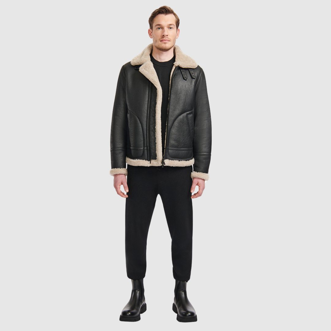 The Ariel Black Beige Shearling Aviator Jacket channels classic aviator style with a modern update, crafted from supple nappa leather and lined with curly wool shearling. Featuring a curly wool collar and trims, oversized welt pockets with stitch detailing, and adjustable buckle details at the collar and waistband, it combines utility with timeless edge. A standard zip closure ensures functionality, while the structured silhouette offers a confident, versatile fit.