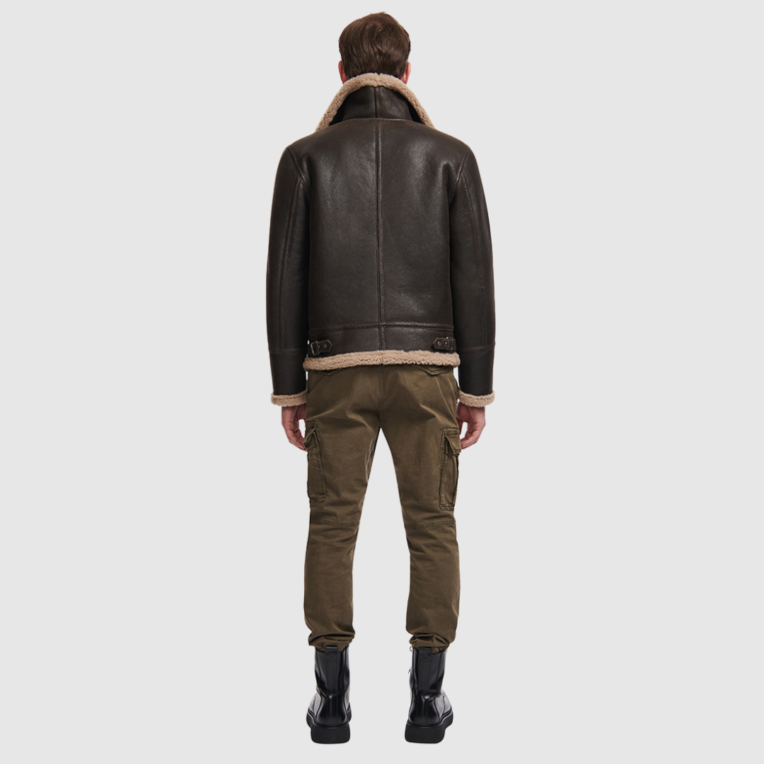 The Ariel Brown Shearling Aviator Jacket channels classic aviator style with a modern update, crafted from supple nappa leather and lined with curly wool shearling. Featuring a curly wool collar and trims, oversized welt pockets with stitch detailing, and adjustable buckle details at the collar and waistband, it combines utility with timeless edge. A standard zip closure ensures functionality, while the structured silhouette offers a confident, versatile fit.