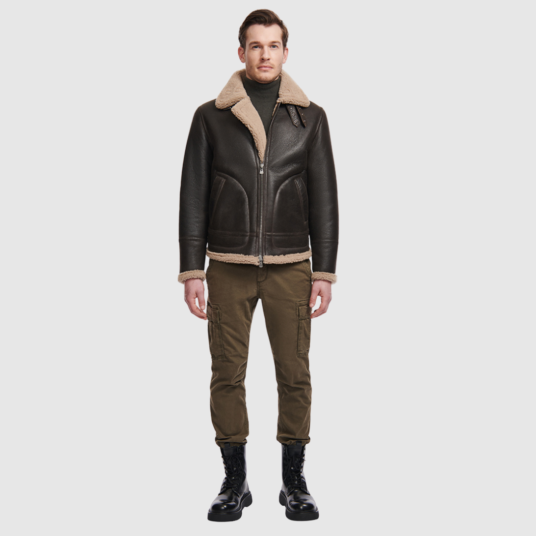 The Ariel Brown Shearling Aviator Jacket channels classic aviator style with a modern update, crafted from supple nappa leather and lined with curly wool shearling. Featuring a curly wool collar and trims, oversized welt pockets with stitch detailing, and adjustable buckle details at the collar and waistband, it combines utility with timeless edge. A standard zip closure ensures functionality, while the structured silhouette offers a confident, versatile fit.