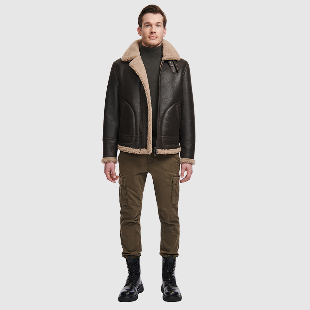 The Ariel Brown Shearling Aviator Jacket channels classic aviator style with a modern update, crafted from supple nappa leather and lined with curly wool shearling. Featuring a curly wool collar and trims, oversized welt pockets with stitch detailing, and adjustable buckle details at the collar and waistband, it combines utility with timeless edge. A standard zip closure ensures functionality, while the structured silhouette offers a confident, versatile fit.