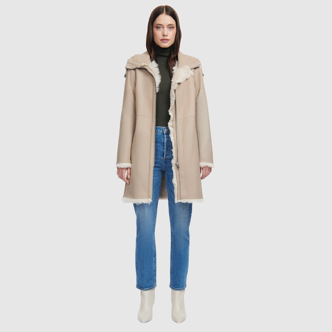 The CAPSULE Coat is a modern mid-length silhouette crafted in luxurious nappa leather shearling. Designed with drop shoulders and a relaxed fit through the body, it offers architectural volume and an easy, natural drape. A plush shearling-lined hood with adjustable drawstrings and a central front zipper closure provide elevated functional protection, while discrete slash side pockets complete the streamlined look. Fully lined with its own natural wool interior, CAPSULE serves as a definitive statement piece
