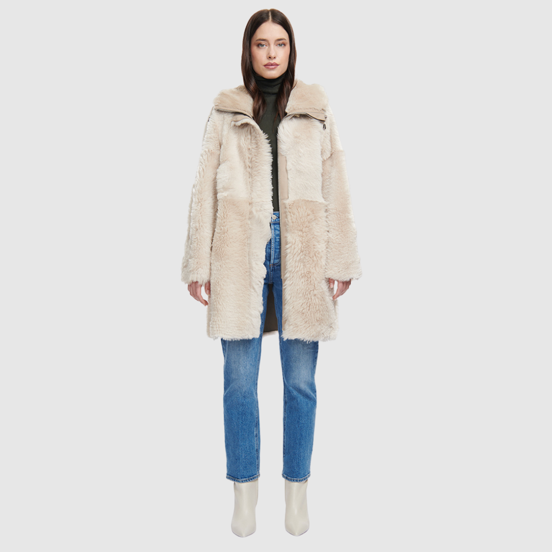The CAPSULE Coat is a modern mid-length silhouette crafted in luxurious nappa leather shearling. Designed with drop shoulders and a relaxed fit through the body, it offers architectural volume and an easy, natural drape. A plush shearling-lined hood with adjustable drawstrings and a central front zipper closure provide elevated functional protection, while discrete slash side pockets complete the streamlined look. Fully lined with its own natural wool interior, CAPSULE serves as a definitive statement piece