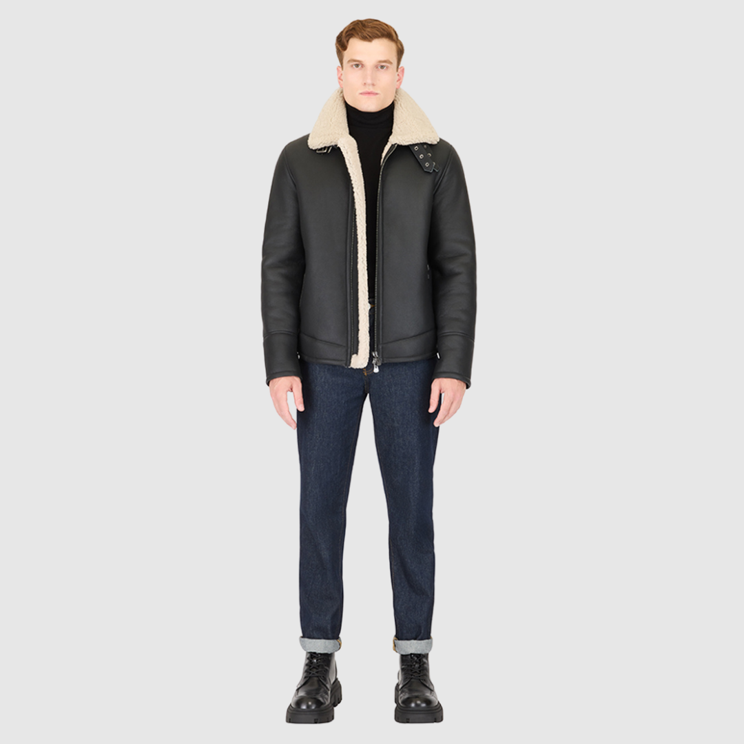 The Code Black Beige Shearling Moto is a bold reinterpretation of a classic moto jacket, merging sleek nappa leather with plush curly wool shearling. Designed for a true-to-size fit, it features a spread collar with a buckle detail for added edge, a standard front zip closure, and an interior zip pocket for functionality. This piece balances rugged refinement with modern versatility, making it a cold-weather essential.