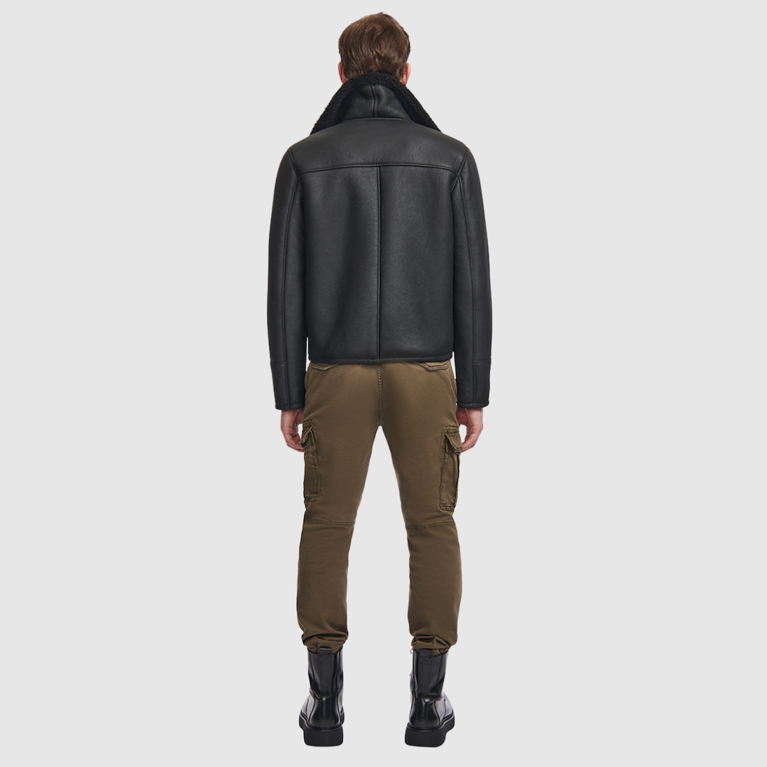 The Code Black Shearling Moto is a bold reinterpretation of a classic moto jacket, merging sleek nappa leather with plush curly wool shearling. Designed for a true-to-size fit, it features a spread collar with a buckle detail for added edge, a standard front zip closure, and an interior zip pocket for functionality. This piece balances rugged refinement with modern versatility, making it a cold-weather essential.