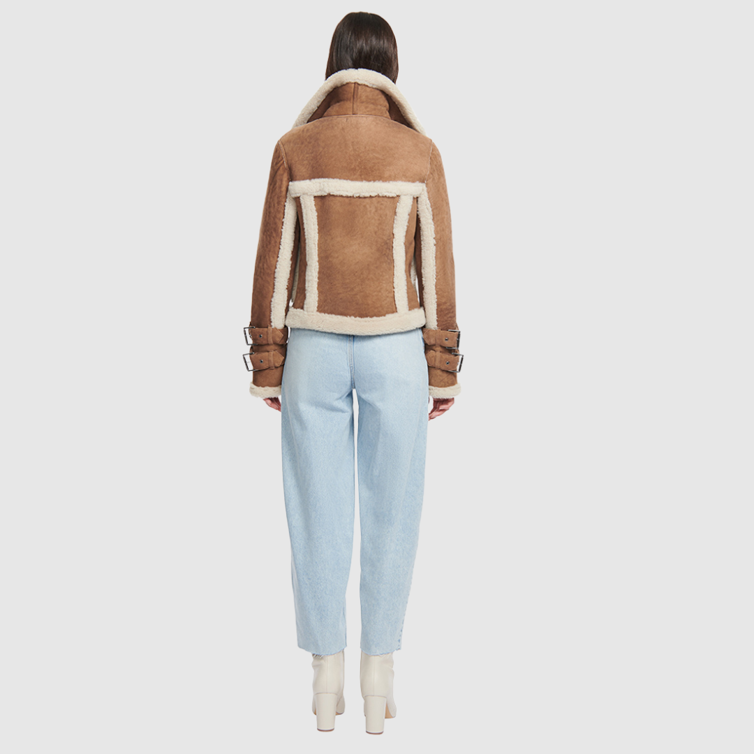 This cropped biker jacket is updated with contrasting wool seams. Crafted in genuine shearling, the jacket is finished with zip pockets and buckle accents at the collar and cuffs. Genuine Shearling Spread collar Long-sleeve Zipper closure Imported