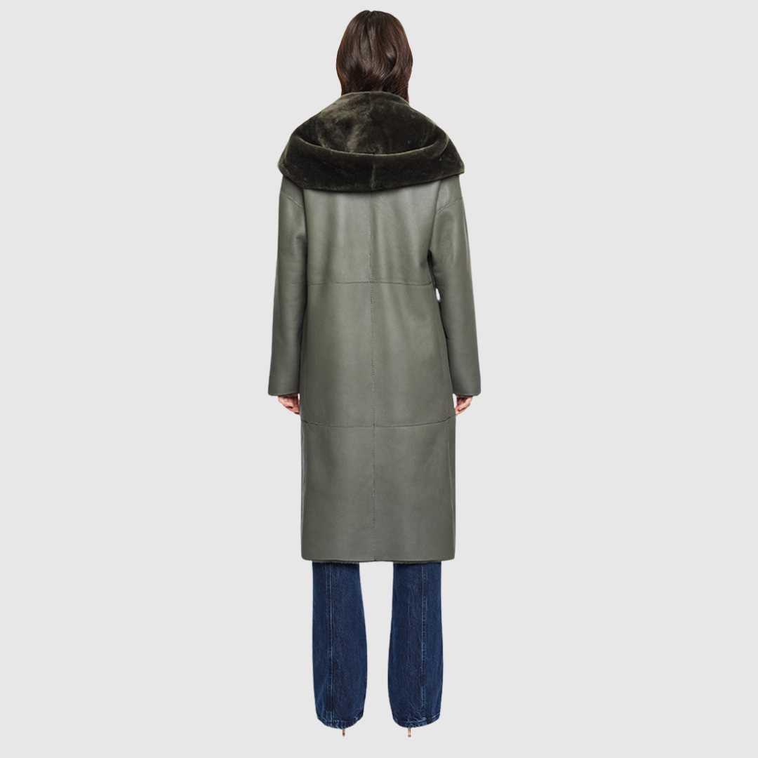 The EVER Reversible Shearling Coat is designed for maximum versatility and modern elegance. Crafted in khaki nappa that reverses to plush ironed wool, it offers two distinct styling options in one oversized silhouette. An oversized hood that converts to a dramatic shawl collar adds functional sophistication, while raw-edge finishing gives it a contemporary edge. With its drop shoulder and pull-through pockets, EVER is a refined statement piece perfect for heritage styling and après-ski layering.
