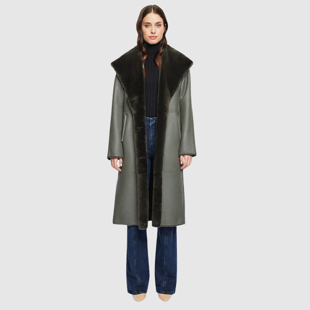 The EVER Reversible Shearling Coat is designed for maximum versatility and modern elegance. Crafted in khaki nappa that reverses to plush ironed wool, it offers two distinct styling options in one oversized silhouette. An oversized hood that converts to a dramatic shawl collar adds functional sophistication, while raw-edge finishing gives it a contemporary edge. With its drop shoulder and pull-through pockets, EVER is a refined statement piece perfect for heritage styling and après-ski layering.