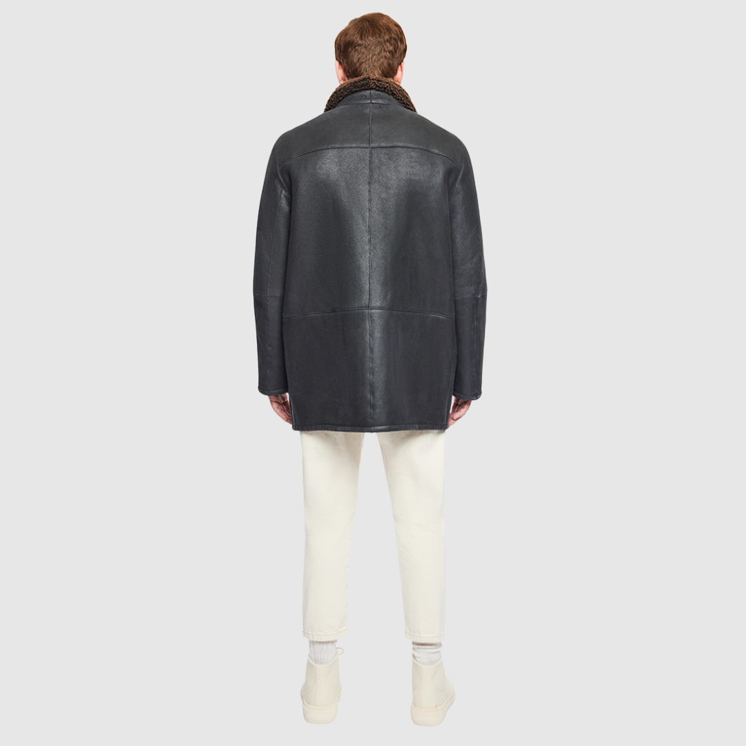 The Jakos Macassar Shearling Jacket is a sleek, contemporary take on a classic shearling coat. Crafted from nappa leather with a curly wool interior, it features a zippered stand collar and a two-way front zip closure concealed by a buttoned placket. Straight-cut through the torso with a regular fit, Jakos combines tailored structure with everyday versatility. Interior and exterior pockets provide functional storage without compromising its clean silhouette.