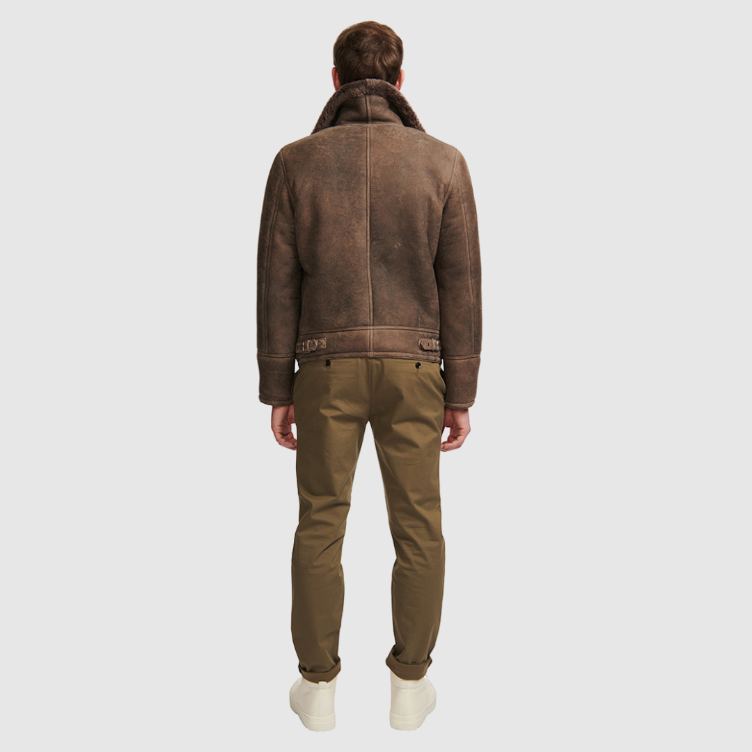The Kane Brown Ancient Shearling Moto combines heritage craftsmanship with modern moto design. Crafted from supple nappa leather with a plush curly wool collar, it fits comfortably through the shoulders and chest for ease of movement. Featuring a notch collar with buckle detailing, interior patch pockets, and exterior single welt side pockets, it balances functional utility with polished style. A front zip closure completes the sleek, timeless silhouette.