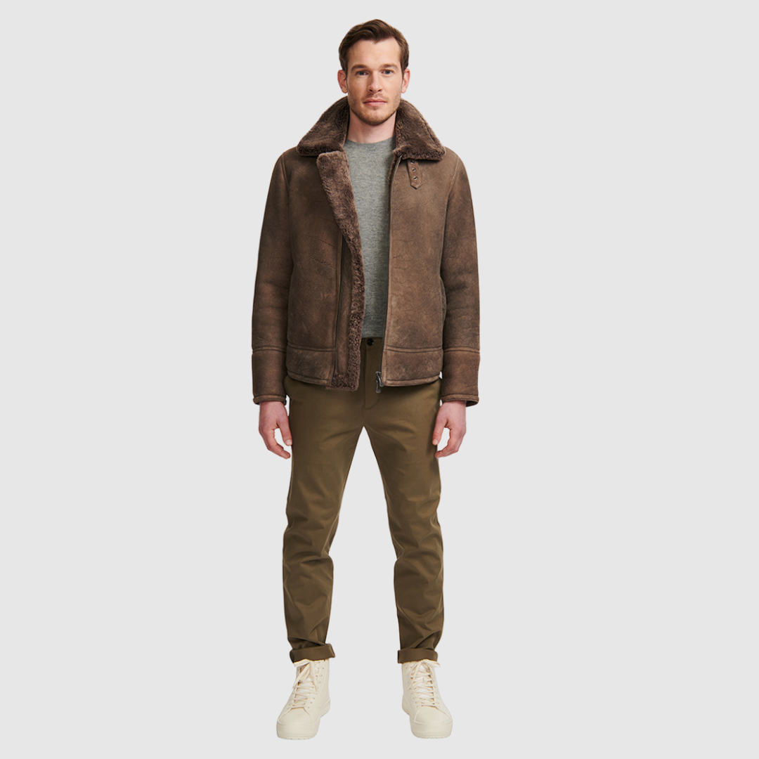 The Kane Brown Ancient Shearling Moto combines heritage craftsmanship with modern moto design. Crafted from supple nappa leather with a plush curly wool collar, it fits comfortably through the shoulders and chest for ease of movement. Featuring a notch collar with buckle detailing, interior patch pockets, and exterior single welt side pockets, it balances functional utility with polished style. A front zip closure completes the sleek, timeless silhouette.