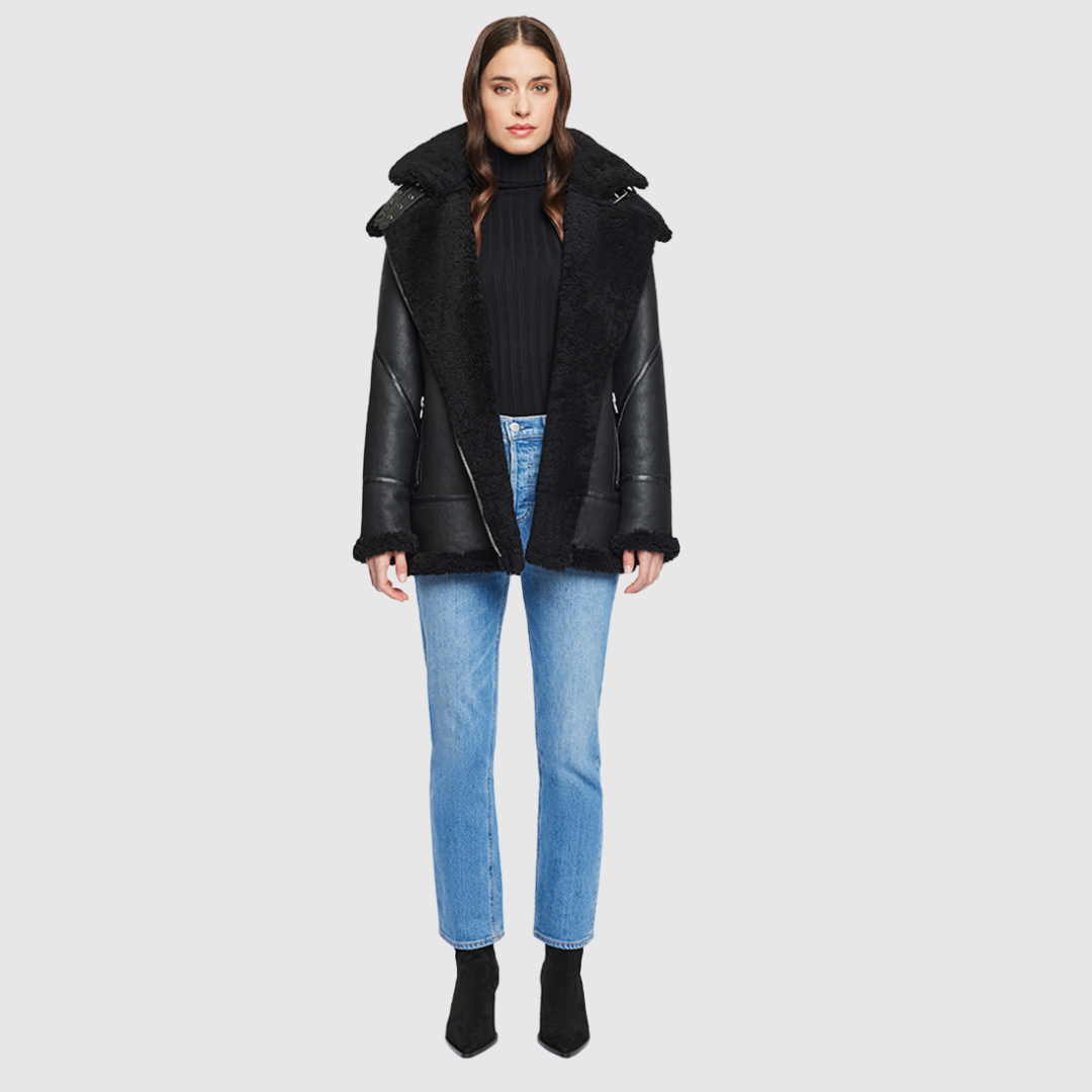 The HiSO Martina Jet Shearling is crafted with a Nappa material and features a relaxed medium length. Along with a curly wool collar and trims, it includes a drop shoulder design and a detachable hood for added convenience. The asymmetrical front zip closure and exterior zip pockets add a sleek touch, while hidden inside pockets provide added functionality.