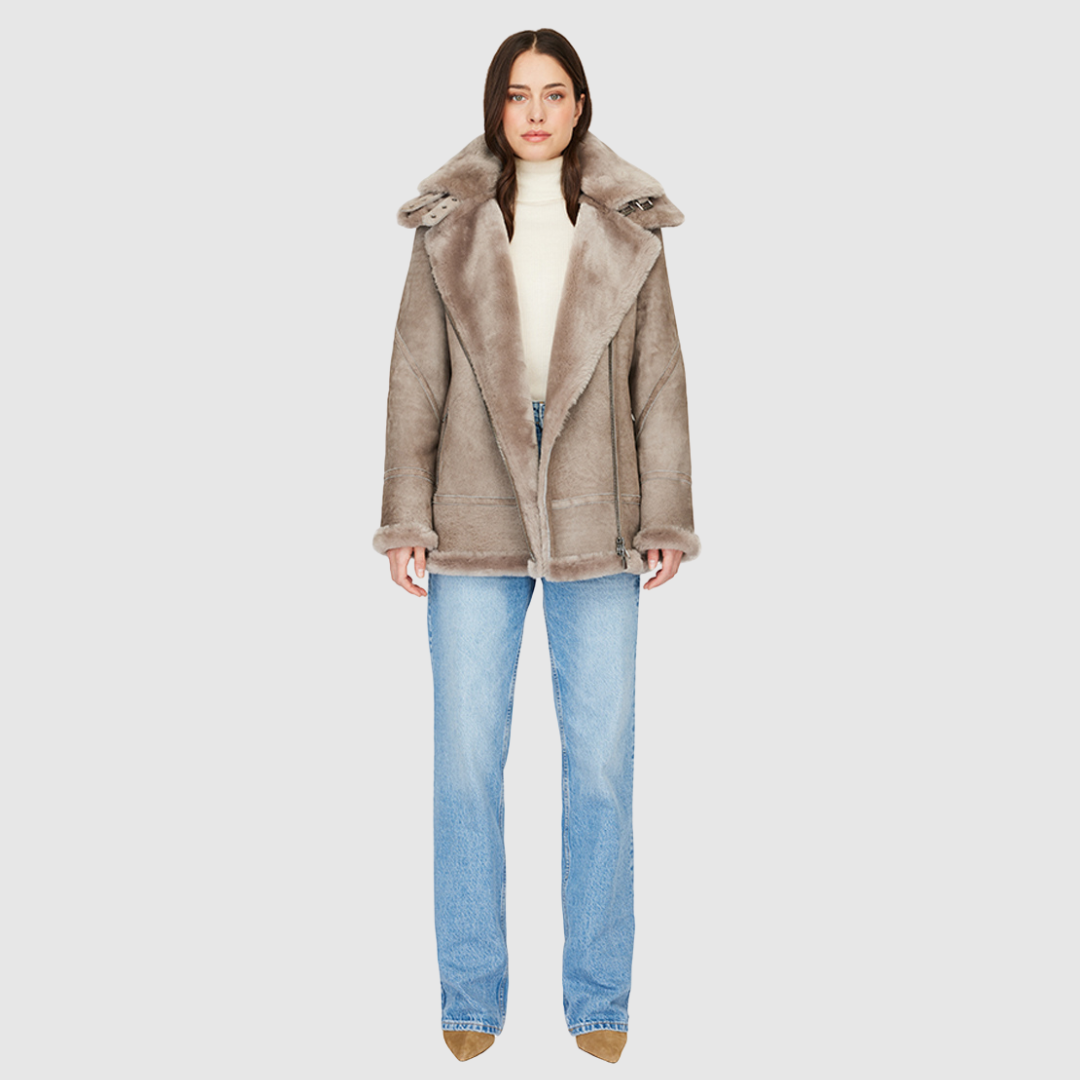 This product features a suede relaxed medium length moto design with an ironed wool collar and trims. It includes a drop shoulder, detachable hood, and an asymmetrical front zip closure. Additionally, there are exterior zip pockets and hidden inside pockets for added functionality.