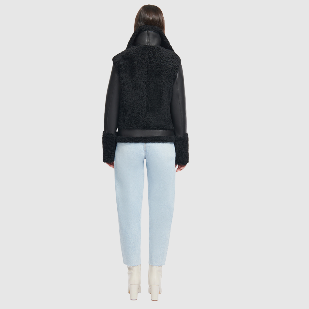 This sleek moto is designed with a high stand collar with double buckle detail and an asymmetrical front zip closure. Crafted in genuine shearling, the jacket is finished with side zip pockets and an interior pocket.