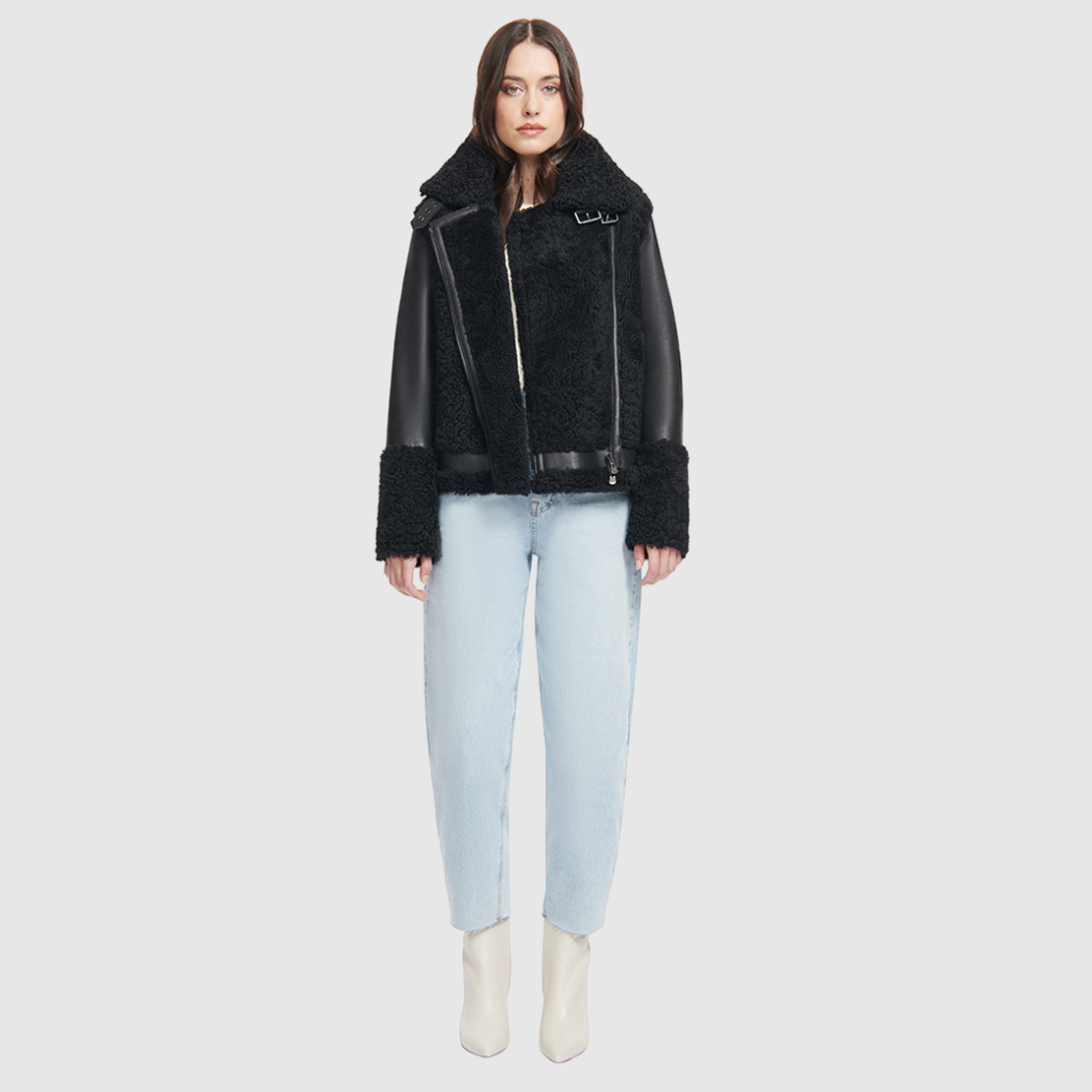 This sleek moto is designed with a high stand collar with double buckle detail and an asymmetrical front zip closure. Crafted in genuine shearling, the jacket is finished with side zip pockets and an interior pocket.