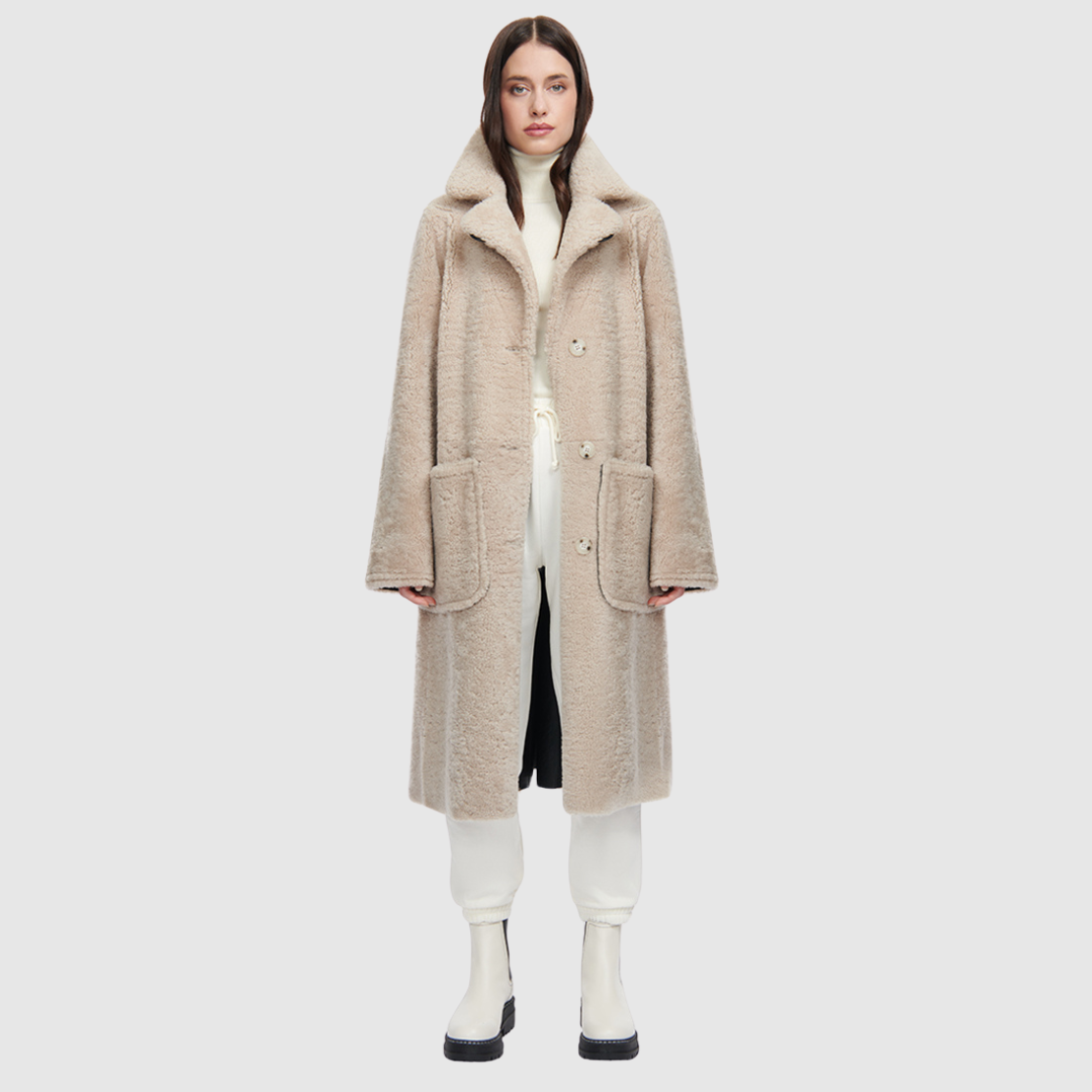 This product features Nappa curly wool shearling with a vintage-inspired, reversible notch collar. On one side, you'll find a soft teddy bear-like texture, while the other boasts a smooth nappa finish. The relaxed, dropped shoulder adds to the overall comfort, and the 3-button closure allows for a secure fit. A tie belt is included for added style on the reversed side, and there are zip pockets on the nappa side, with patch pockets on the teddy side.