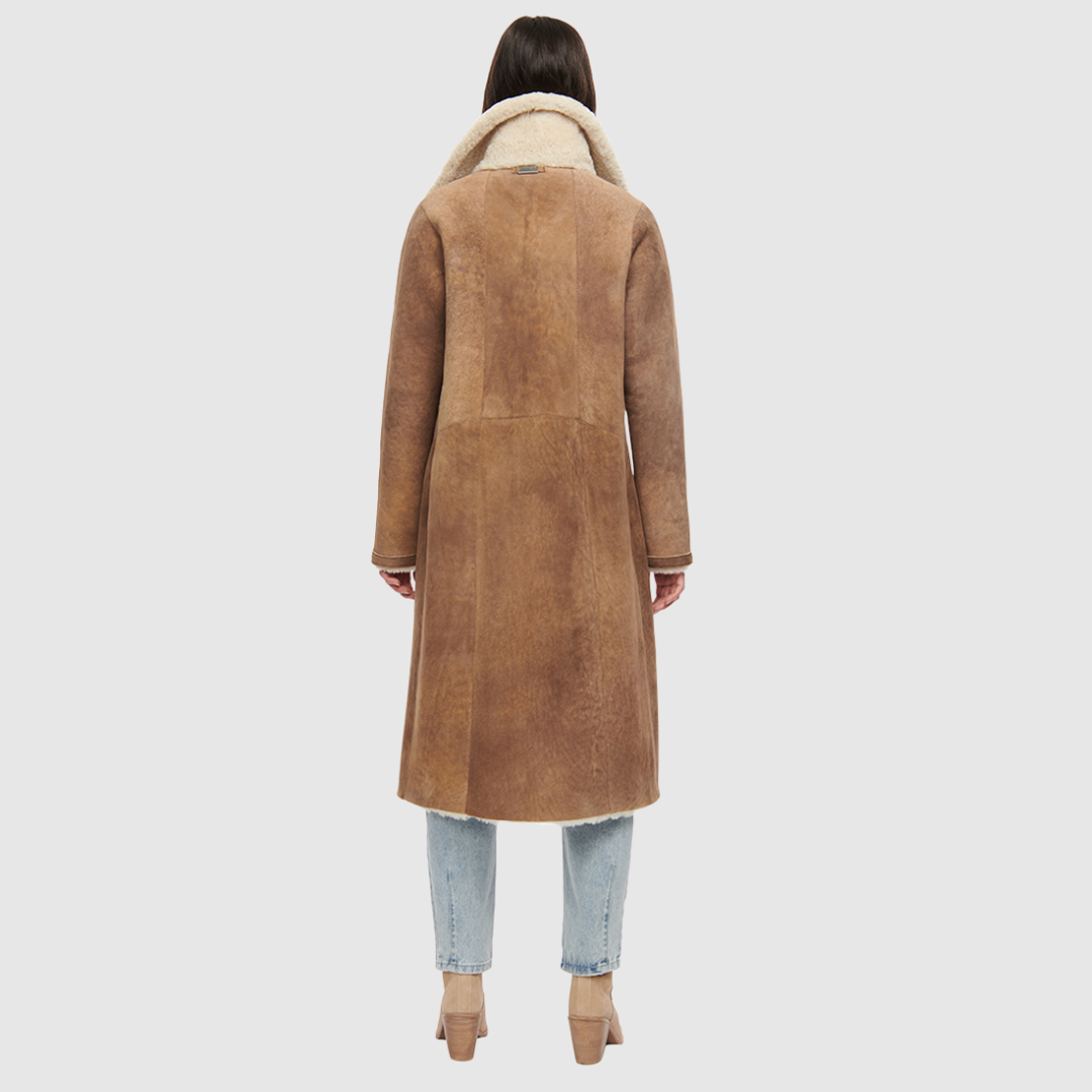Suede curly wool shearling Vintage inspired reversible notch collar Reverses to curly wool teddy Relaxed dropped shoulder 3 button closure Tie belt at waist Zip pockets on suede side, reverses to patch pockets on teddy side