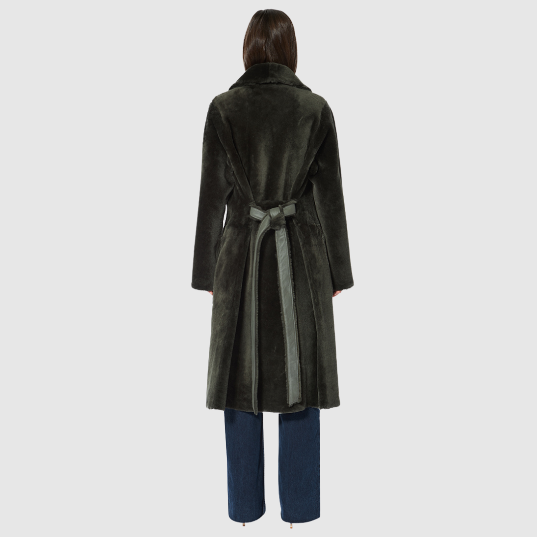 This reversible HiSO Zira Khaki Shearling Coat features an ironed wool design with a vintage-inspired look. Its notch collar provides a classic touch, while the dropped shoulder and tie belt at the waist add a relaxed yet elegant feel. The coat also includes 3 buttons for closure and zip pockets on the nappa side, with patch pockets on the teddy side.