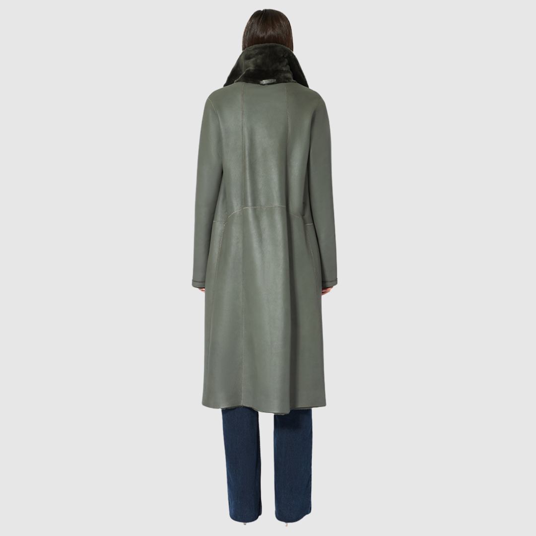This reversible HiSO Zira Khaki Shearling Coat features an ironed wool design with a vintage-inspired look. Its notch collar provides a classic touch, while the dropped shoulder and tie belt at the waist add a relaxed yet elegant feel. The coat also includes 3 buttons for closure and zip pockets on the nappa side, with patch pockets on the teddy side.