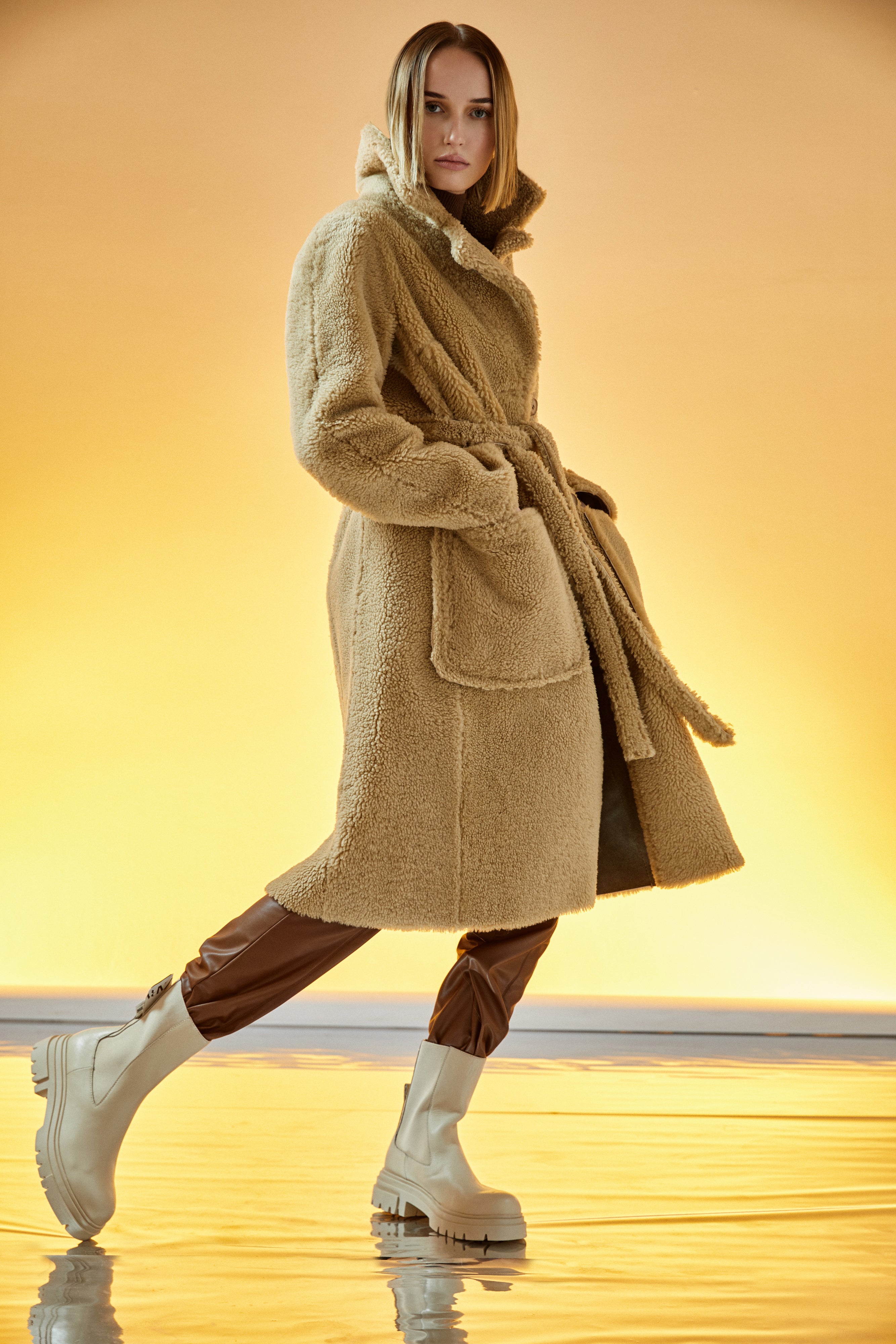 Zira: This elegant, reversible full-length shearling coat offers two beautiful styles in one. 51" long. It reverses from a beautiful nappa finish to a plush fur-out style and has two slip pockets. Made from genuine Spanish merino shearling sheepskin. Double breasted. Slight dropped shoulder fits comfortably across the shoulders. Loose fit through the torso.