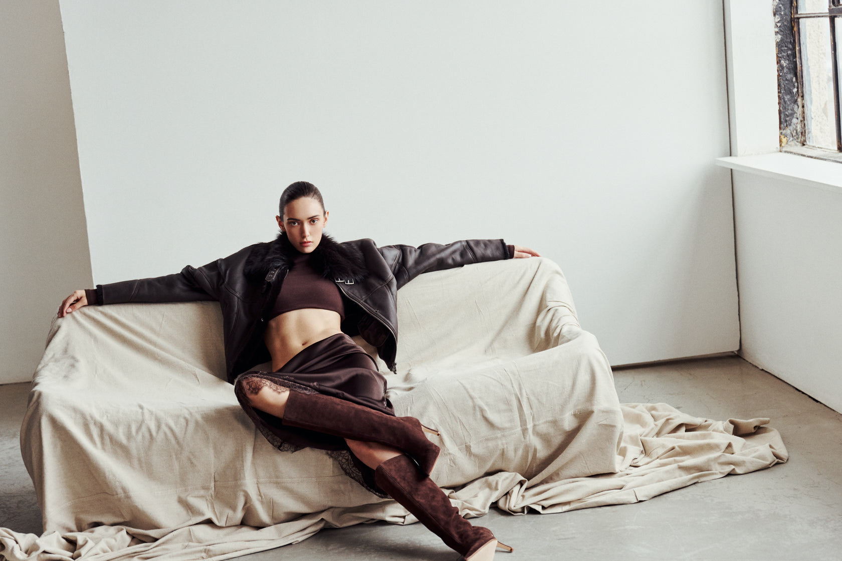 The CLARITY shearling bomber jacket offers a modern take on the classic bomber jacket, combining rugged function with luxurious texture. Crafted in a rich nappa leather and plush, dark rasado shearling wool interior, it delivers an elevated cold-weather look. Designed with a drop shoulder and a high shearling collar, it balances structure with relaxed ease. A tonal ribbed knit waistband, structural paneling, and clean hardware details lend utility to this elegant semi-fitted style