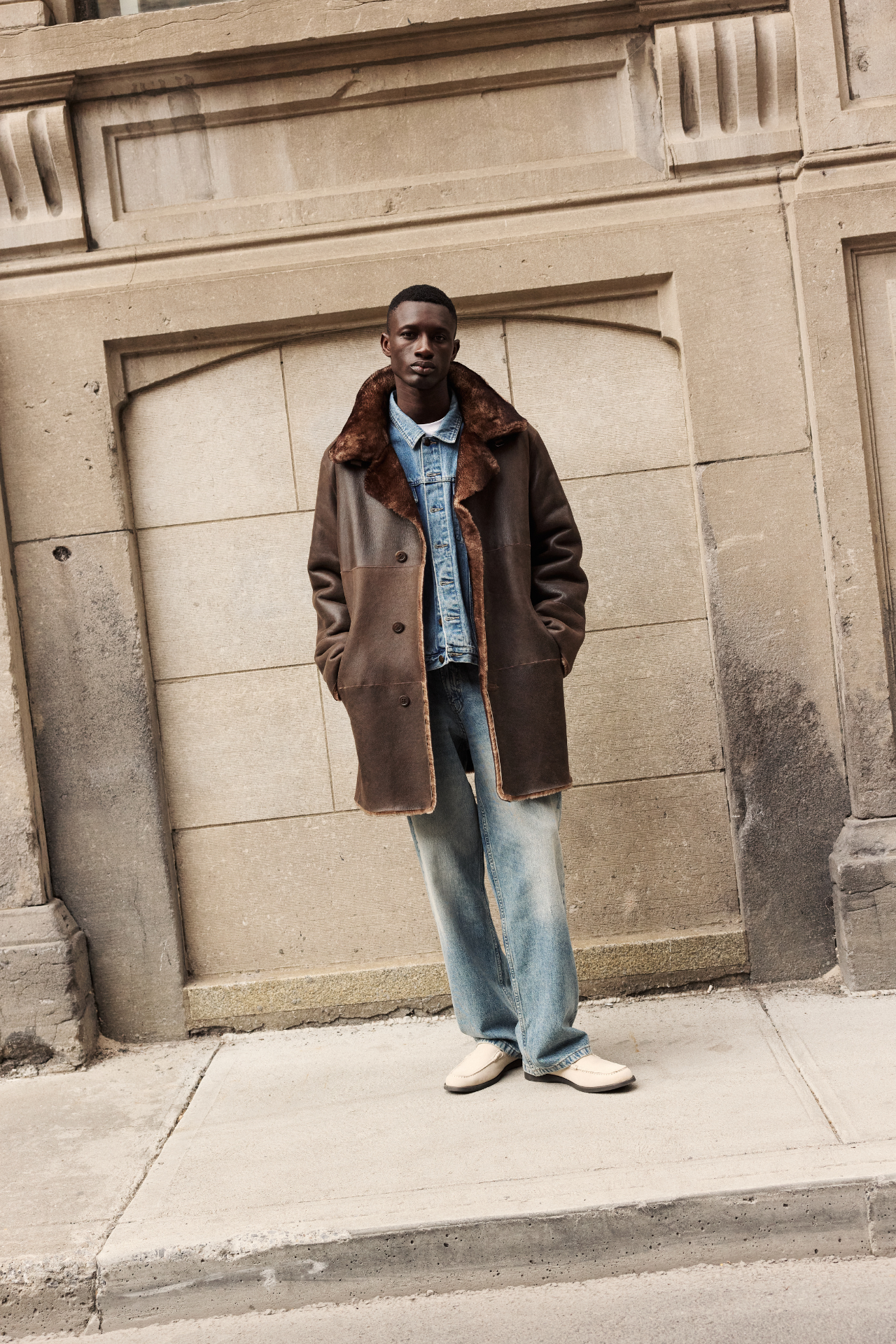 Discover this reversible suede medium-length coat with plush iron wool teddy shearling reverse. Fits true to size when worn suede side out and looser with the wool side out. Raw edge finish and spread collar with tab amplify modern appeal. Single-breasted button closure secures two pocket styles: a sleek welt pocket on the suede side and a convenient slash pocket on the iron wool side. Perfect as a versatile outerwear coat or statement jacket.