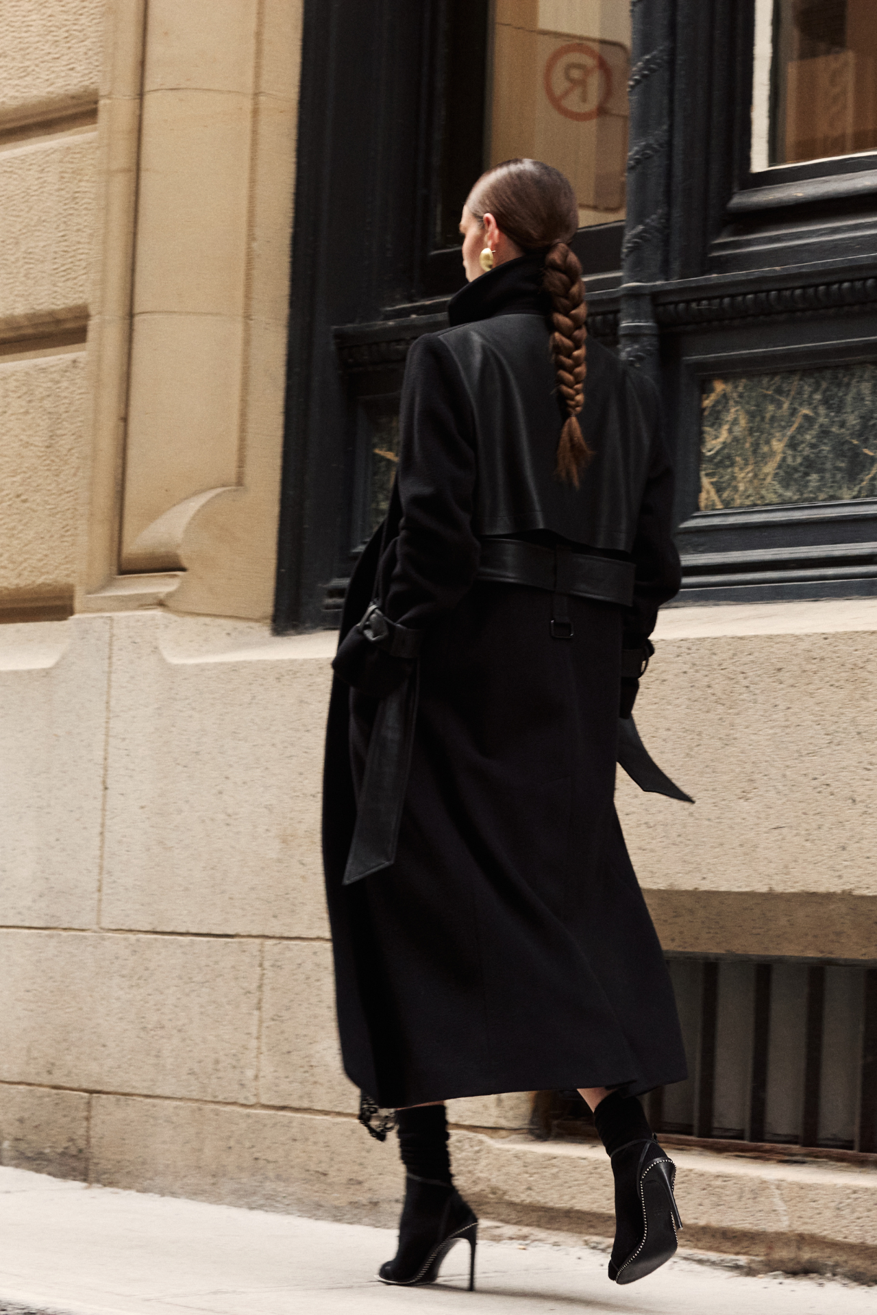 This sophisticated women's coat is a stylish wool trench coat featuring chic leather detail accents and distinctive sleeve straps. It boasts a classic notched collar. This elegant piece of outerwear offers a timeless silhouette. A perfect wool trench coat for a polished look.
