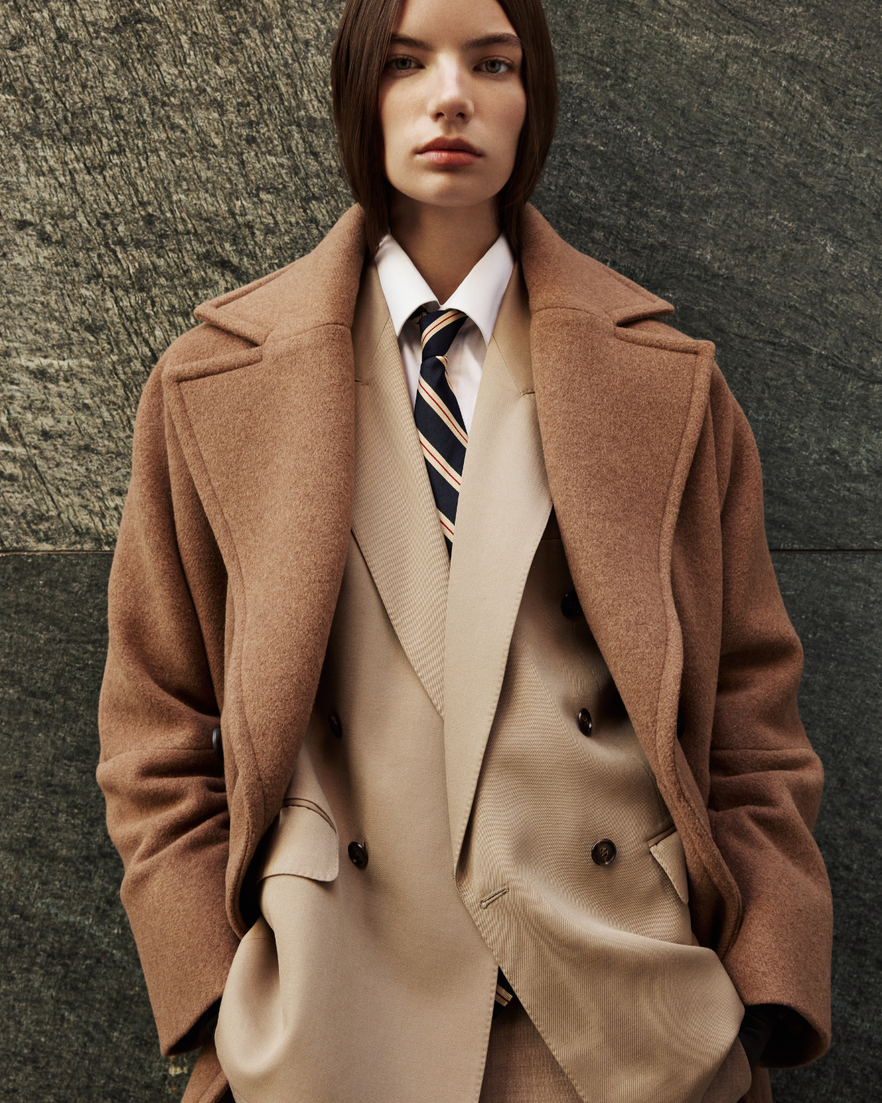 This elegant women's coat is a sophisticated piece of outerwear crafted from a luxurious Italian wool cashmere blend. This longline coat features a relaxed fit and an oversized fit through the shoulders, arms, and torso, complemented by a stylish drop shoulder. The classic double-breasted design is enhanced by a large notch collar and practical single welt pockets. A back vent adds ease of movement to this refined wool coat. This versatile coat offers both warmth and timeless appeal. A must-have jacket.