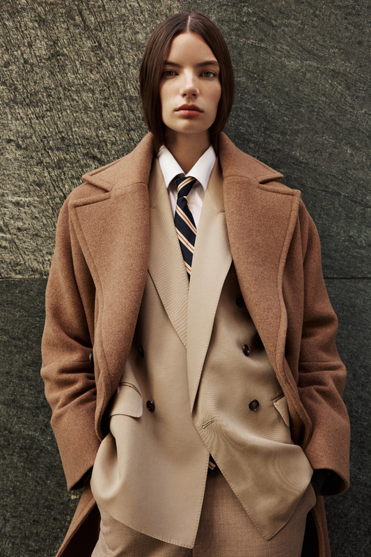 This elegant women's coat is a sophisticated piece of outerwear crafted from a luxurious Italian wool cashmere blend. This longline coat features a relaxed fit and an oversized fit through the shoulders, arms, and torso, complemented by a stylish drop shoulder. The classic double-breasted design is enhanced by a large notch collar and practical single welt pockets. A back vent adds ease of movement to this refined wool coat. This versatile coat offers both warmth and timeless appeal. A must-have jacket.