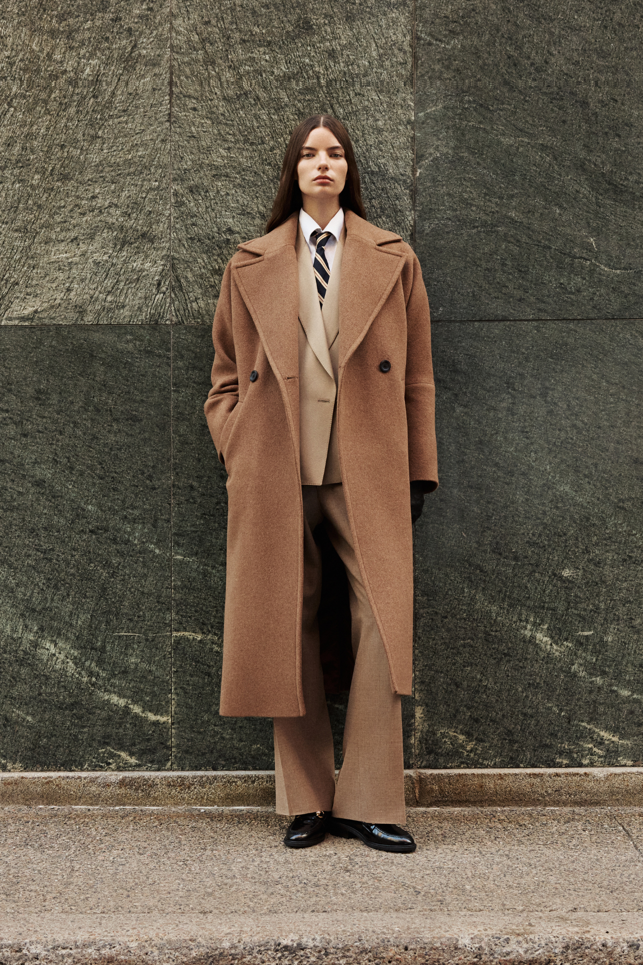 This elegant women's coat is a sophisticated piece of outerwear crafted from a luxurious Italian wool cashmere blend. This longline coat features a relaxed fit and an oversized fit through the shoulders, arms, and torso, complemented by a stylish drop shoulder. The classic double-breasted design is enhanced by a large notch collar and practical single welt pockets. A back vent adds ease of movement to this refined wool coat. This versatile coat offers both warmth and timeless appeal. A must-have jacket.