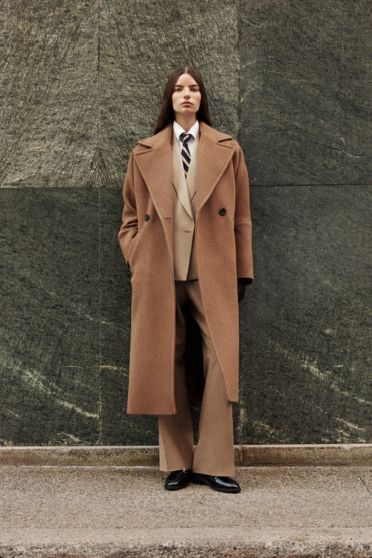 This elegant women's coat is a sophisticated piece of outerwear crafted from a luxurious Italian wool cashmere blend. This longline coat features a relaxed fit and an oversized fit through the shoulders, arms, and torso, complemented by a stylish drop shoulder. The classic double-breasted design is enhanced by a large notch collar and practical single welt pockets. A back vent adds ease of movement to this refined wool coat. This versatile coat offers both warmth and timeless appeal. A must-have jacket.